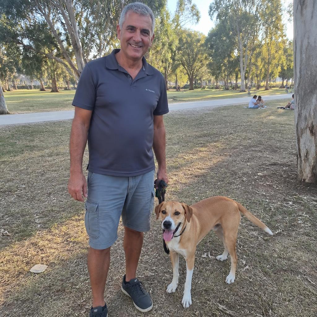 רקסי, כלב מעורב בינוני, והבעלים המבוגר שלו מחייכים למצלמה